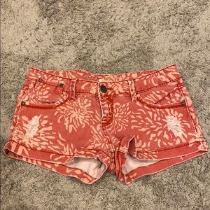 Red distressed shorts with floral pattern